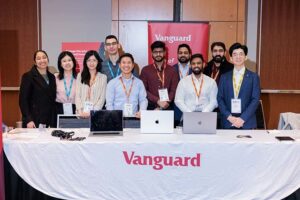 A group of Vanguard employees pose for a photo at the 2024 Applied Research in Action (ARIA) showcase.